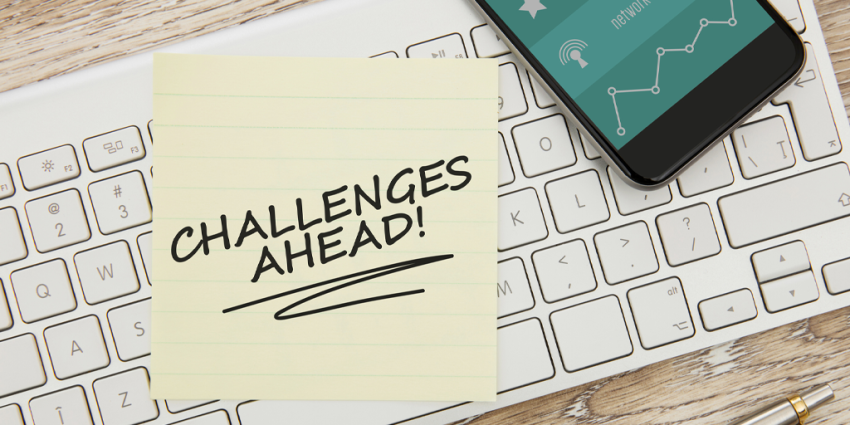 A keyboard with a post-it note reading "Challenges Ahead."